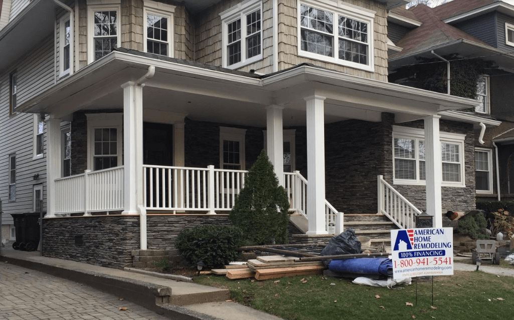 House exterior with white porch railings and a real estate sign in front