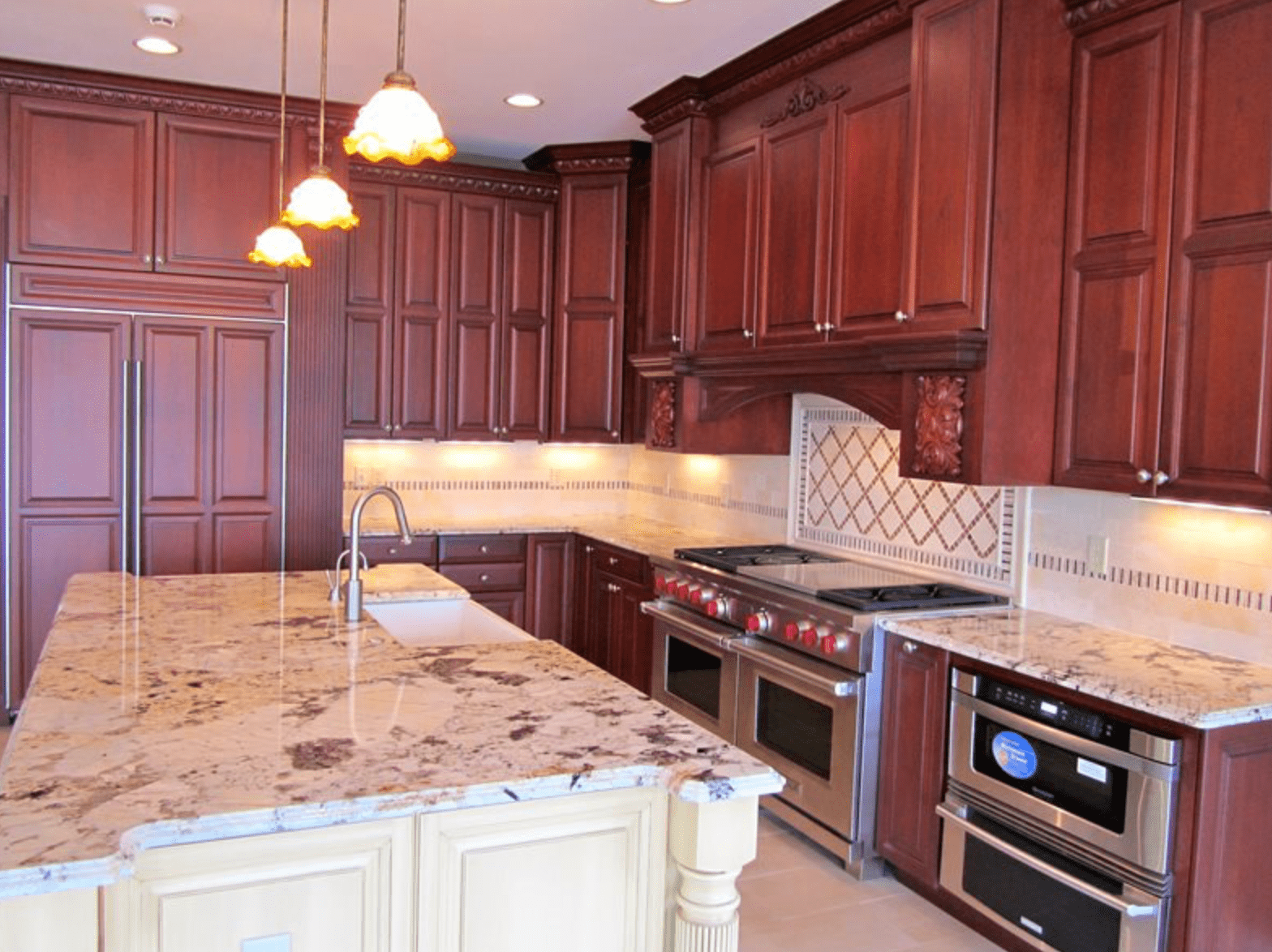 Modern kitchen with dark wood cabinets, granite island, stainless steel appliances, and pendant lights