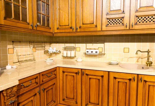 Wooden kitchen with cabinets, beige tile backsplash, countertop, sink, and hanging lights