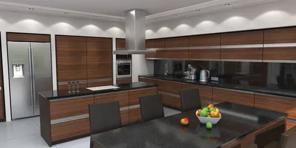 Modern kitchen with wood cabinets, black island seating, stainless fridge, and a fruit bowl on the table
