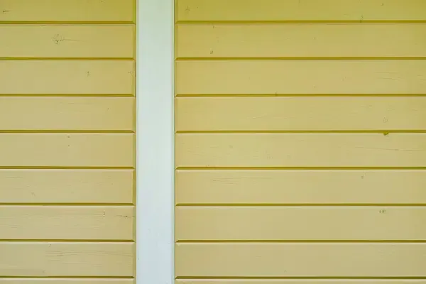 Beige horizontal siding with a white vertical trim strip in the center.