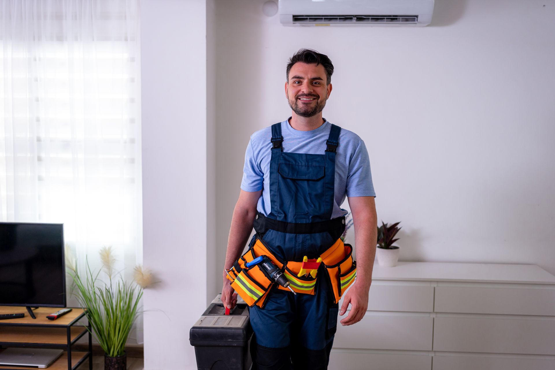 Air conditioning contractor ready for repairs in a comfortable indoor setting during the day. Air conditioning contractor ready for repairs in a comfortable indoor setting during the day.
