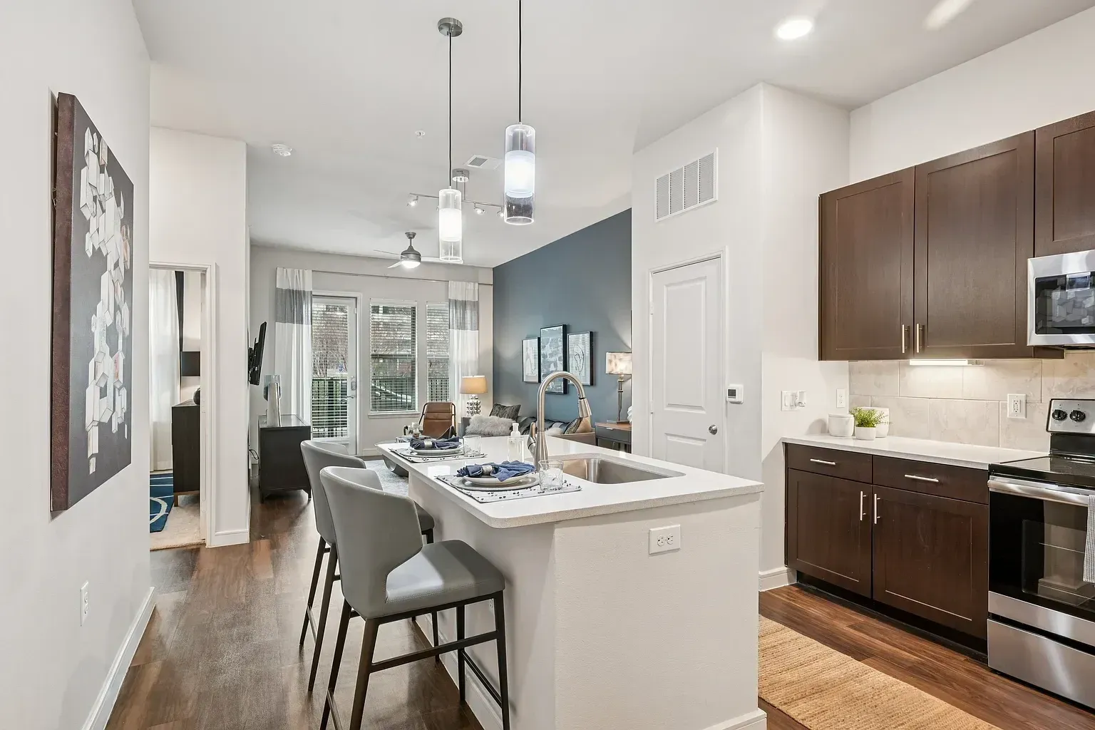 Modern kitchen with island seating and open-concept living area.