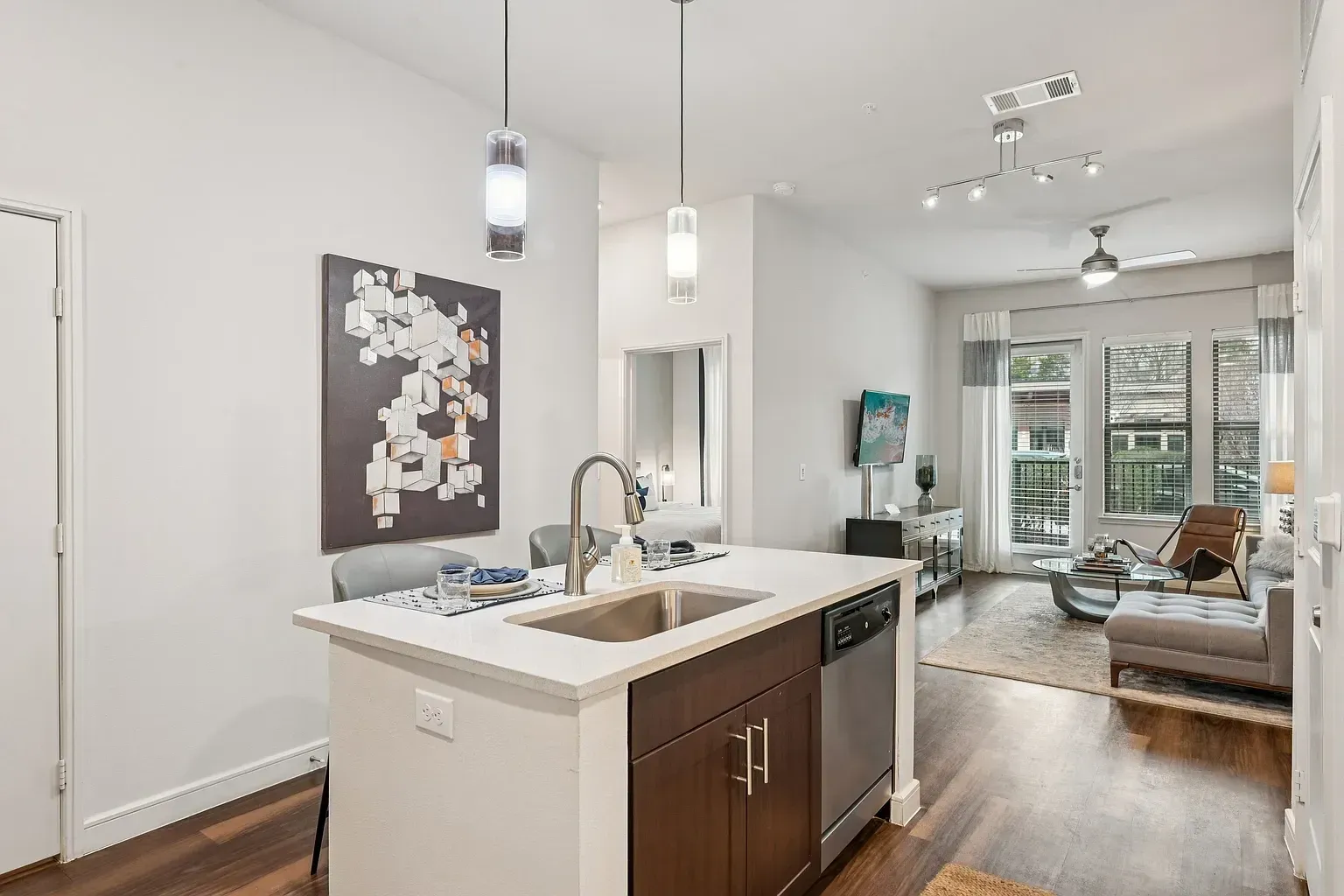 Modern kitchen island with sink and dishwasher in an open-concept living space.