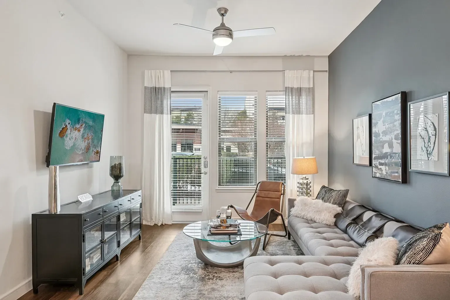 Living room with sectional couch, leather accent chair, coffee table, and TV.