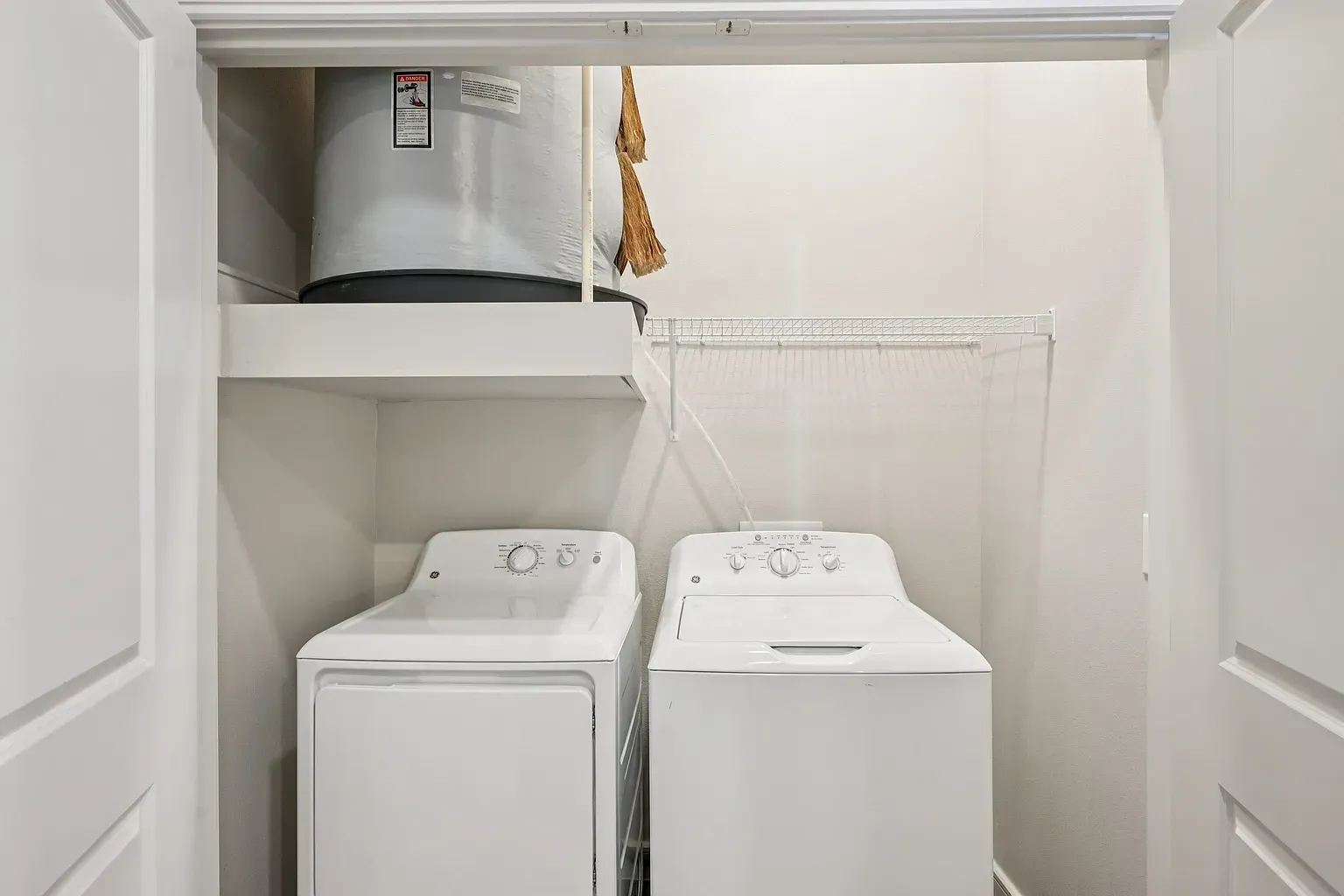 Stackable washer and dryer unit with a water heater above