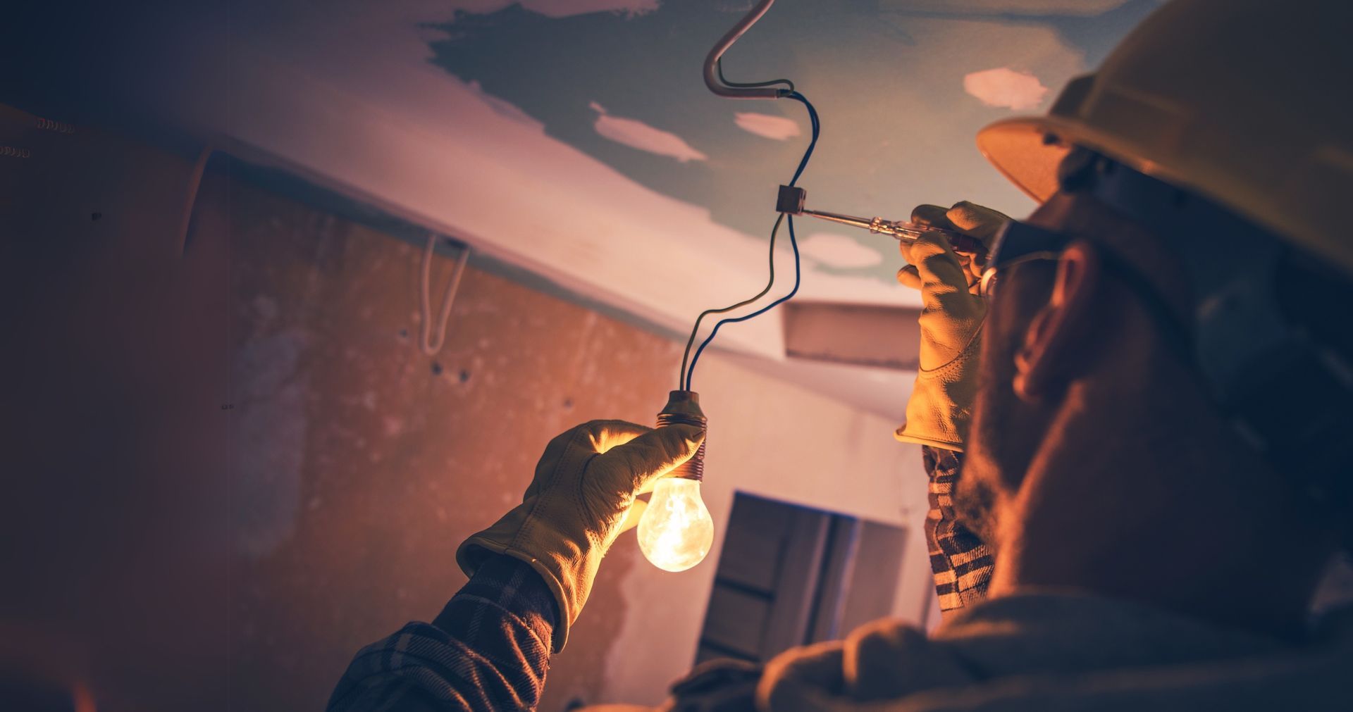 A man is holding a light bulb in his hand.