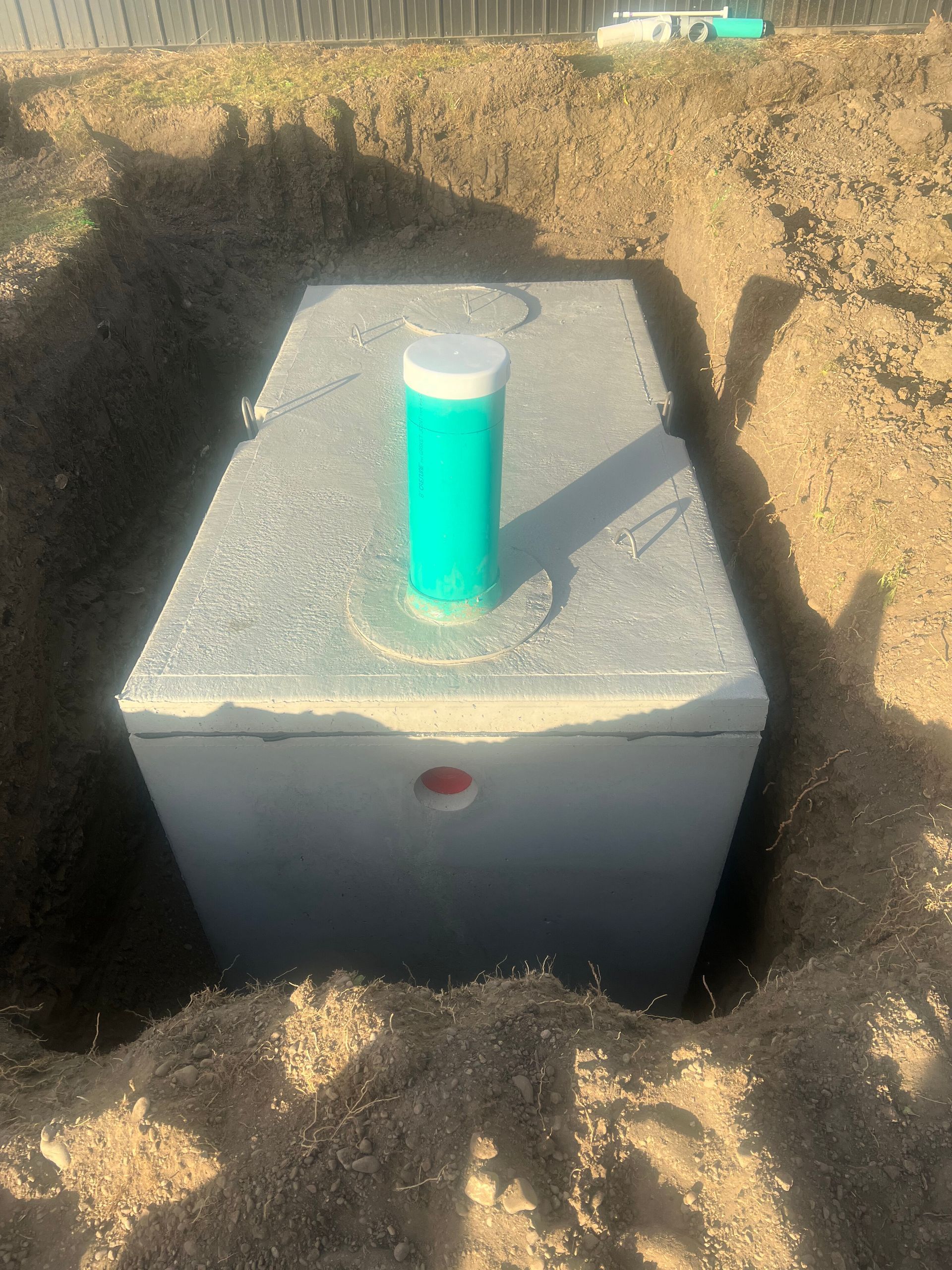 White box in a dirt trench with a turquoise test tube on top.