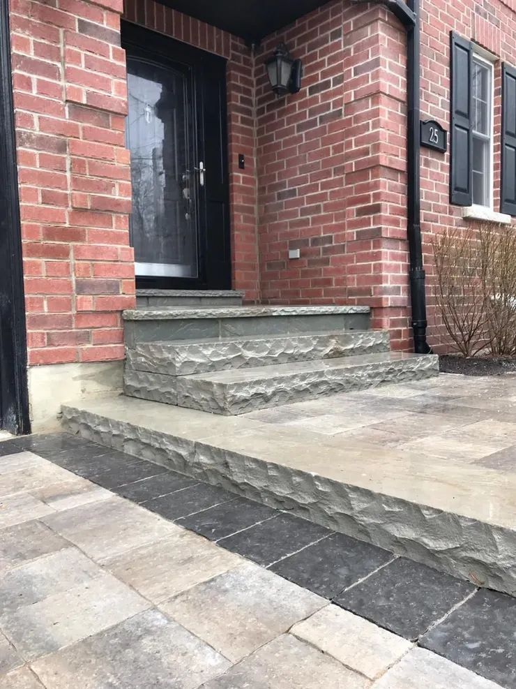 A brick house with stone steps leading up to the front door.