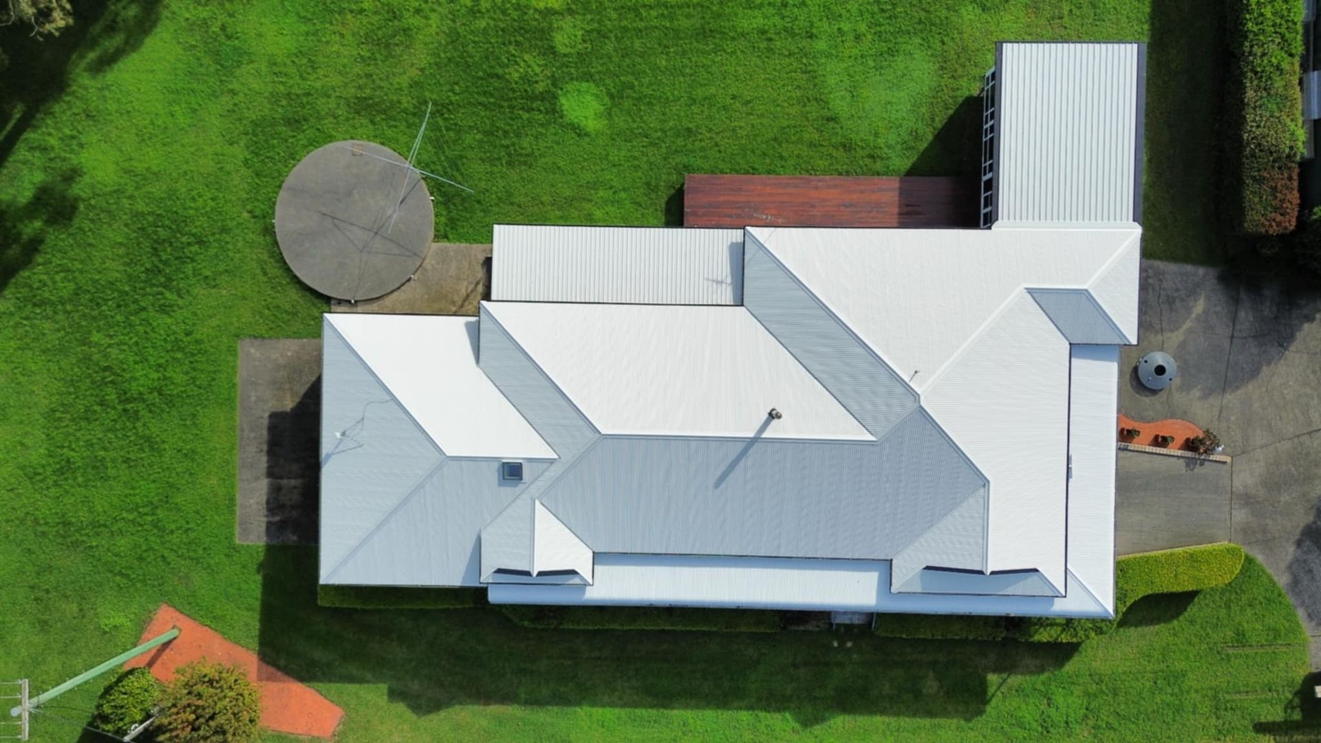 An Aerial View of a Large House With a Pool in the Backyard Surrounded by Trees — Tim Leach Metal Roofing in Wauchope, NSW