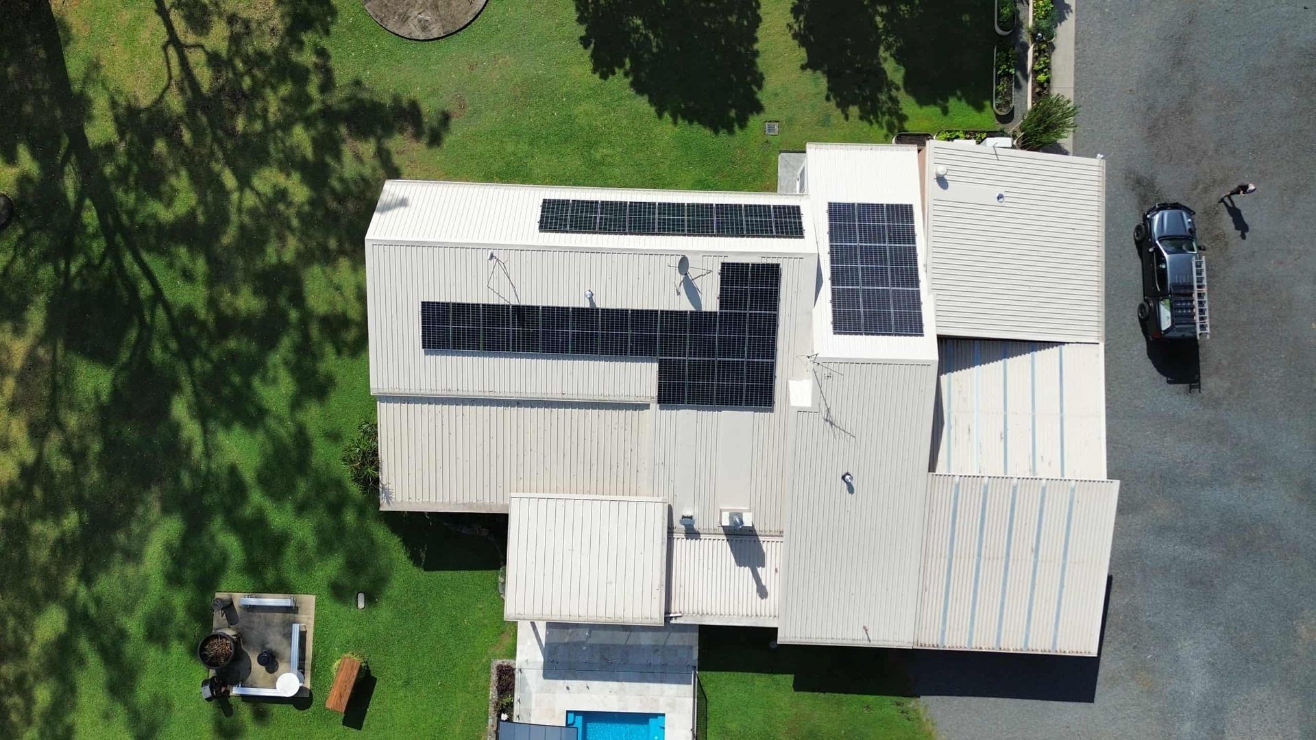 Aerial View of a House With Solar Panels on the Roof and a Vehicle — Tim Leach Metal Roofing in Wauchope, NSW