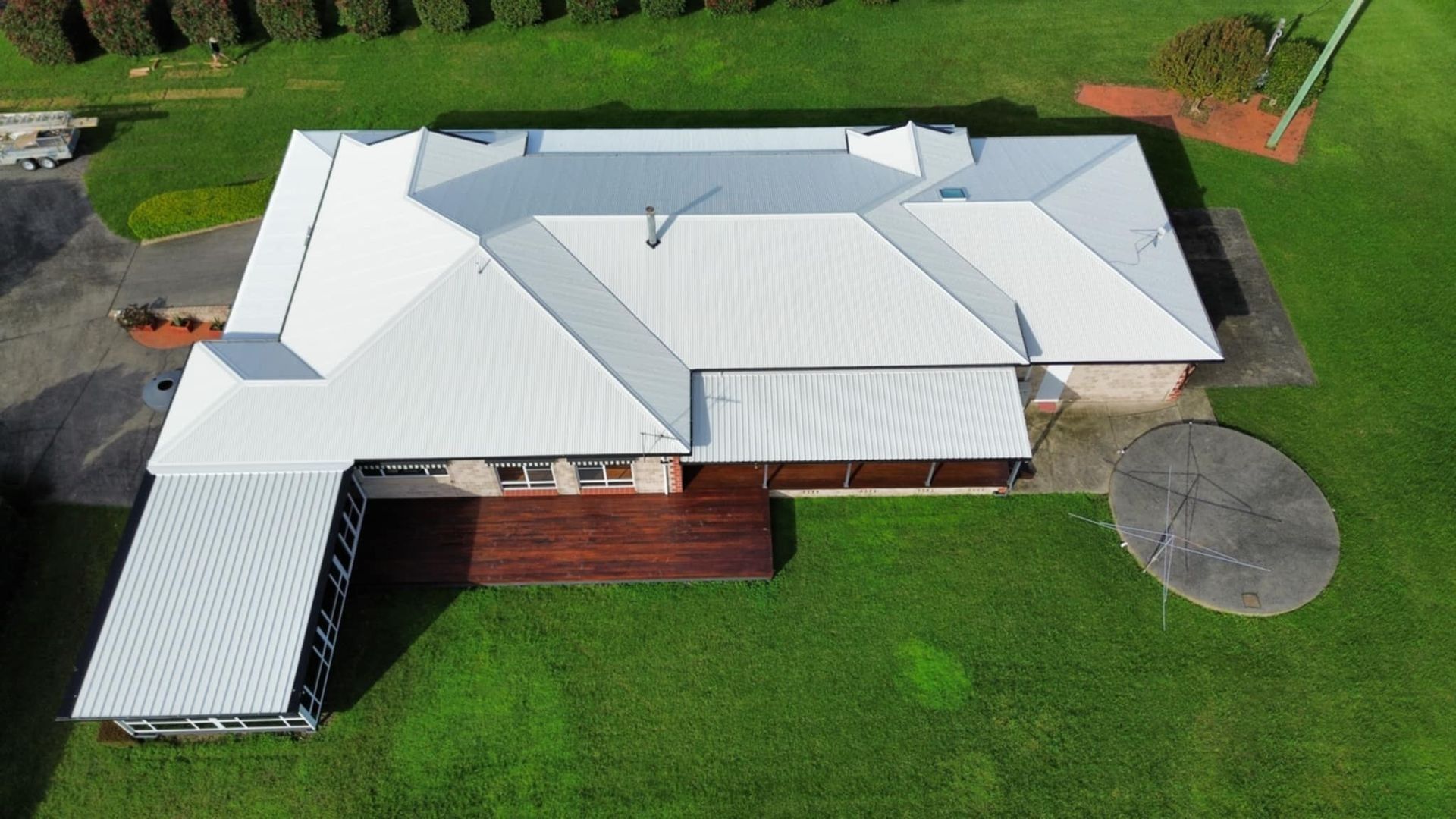 Aerial View of a White-roofed House With a Wooden Deck and a Green Lawn — Tim Leach Metal Roofing in Wauchope, NSW