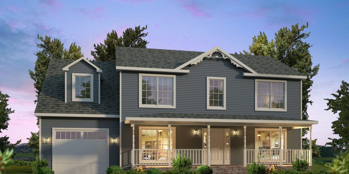 Two-story gray house with a front porch, white trim, and lit windows at dusk