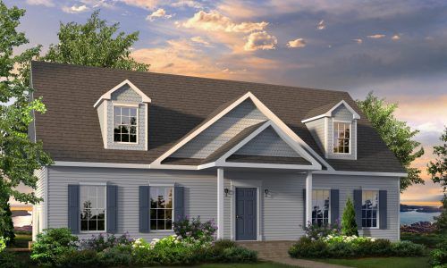 Blue-gray suburban house with white trim, dormer windows, and a front porch under a warm sunset sky