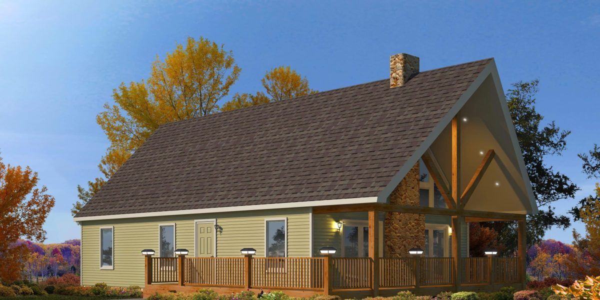 Small beige house with brown roof and porch in a wooded autumn setting at sunset