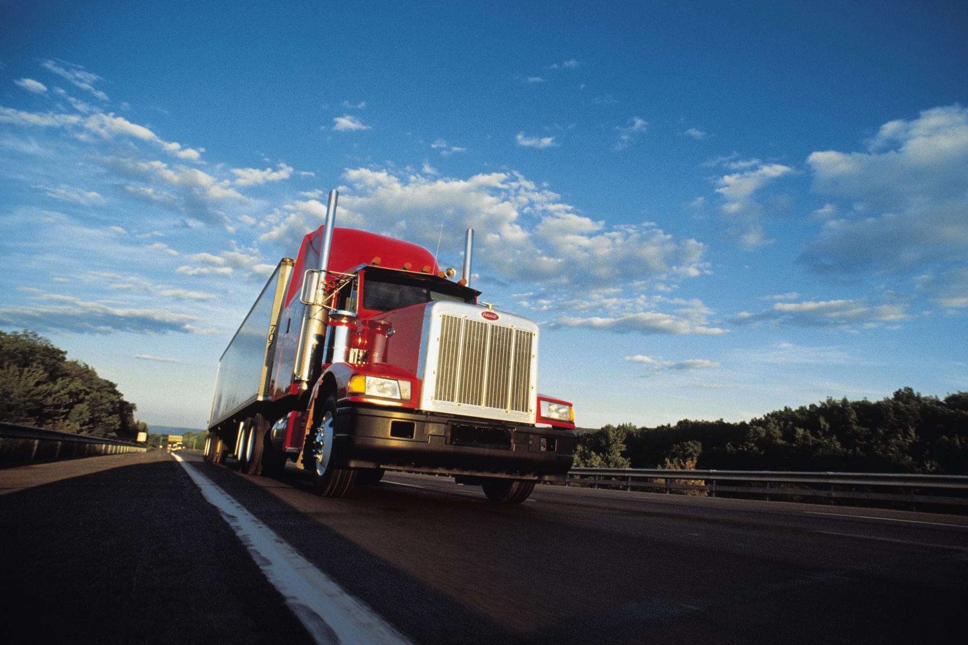 Red semi truck driving down road