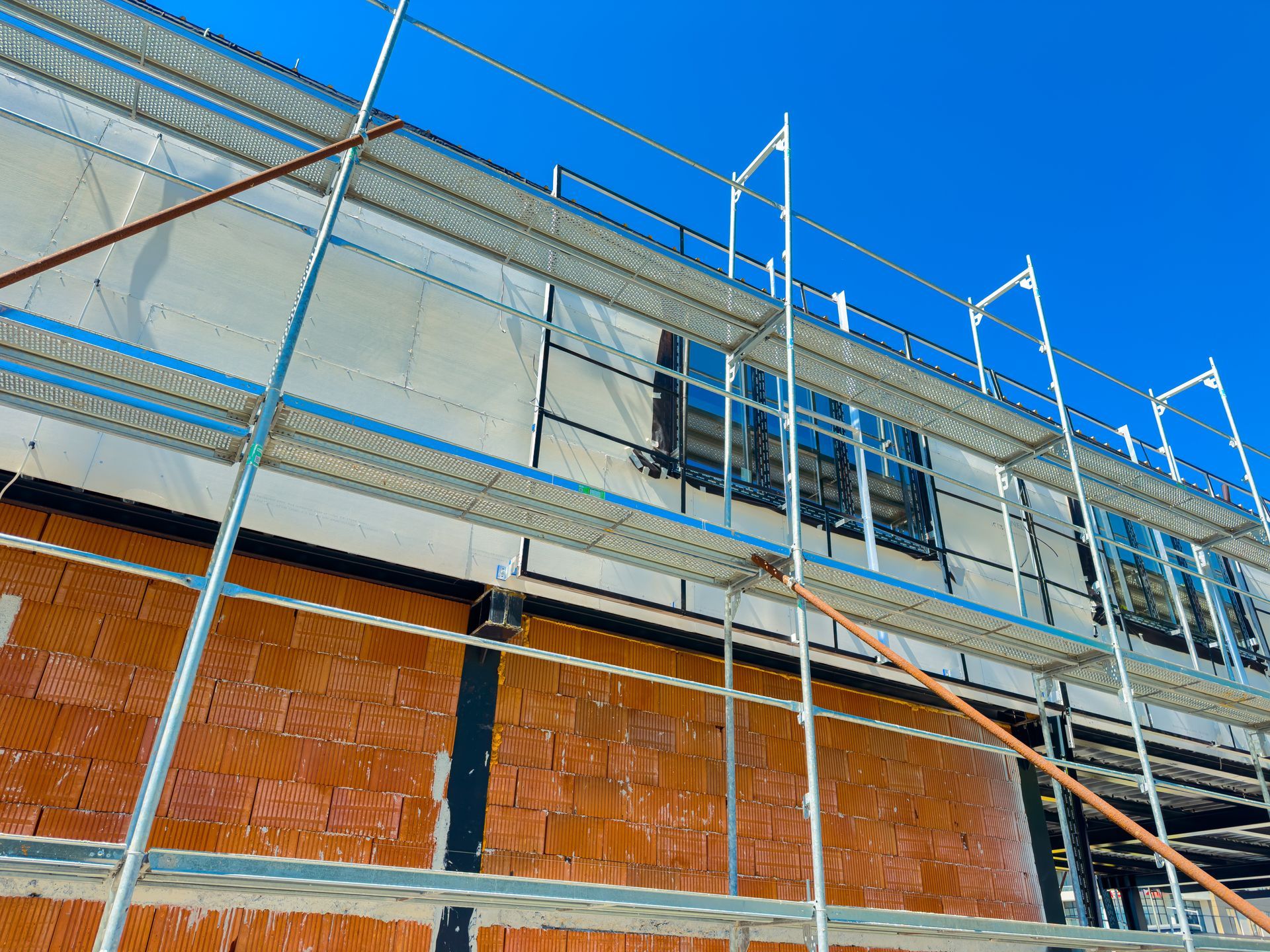 Outside view of a building under construction with aluminium scaffolding set up.