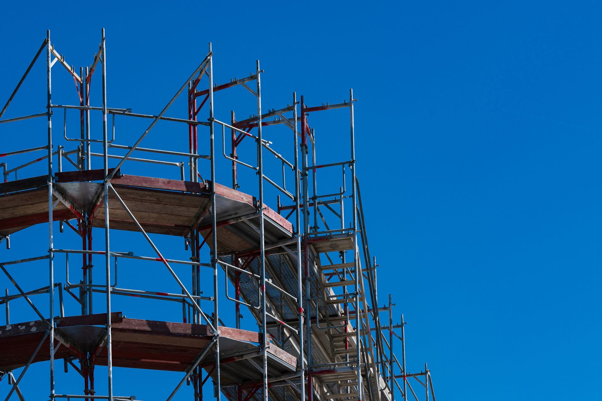 Scaffolding against a bright blue sky.