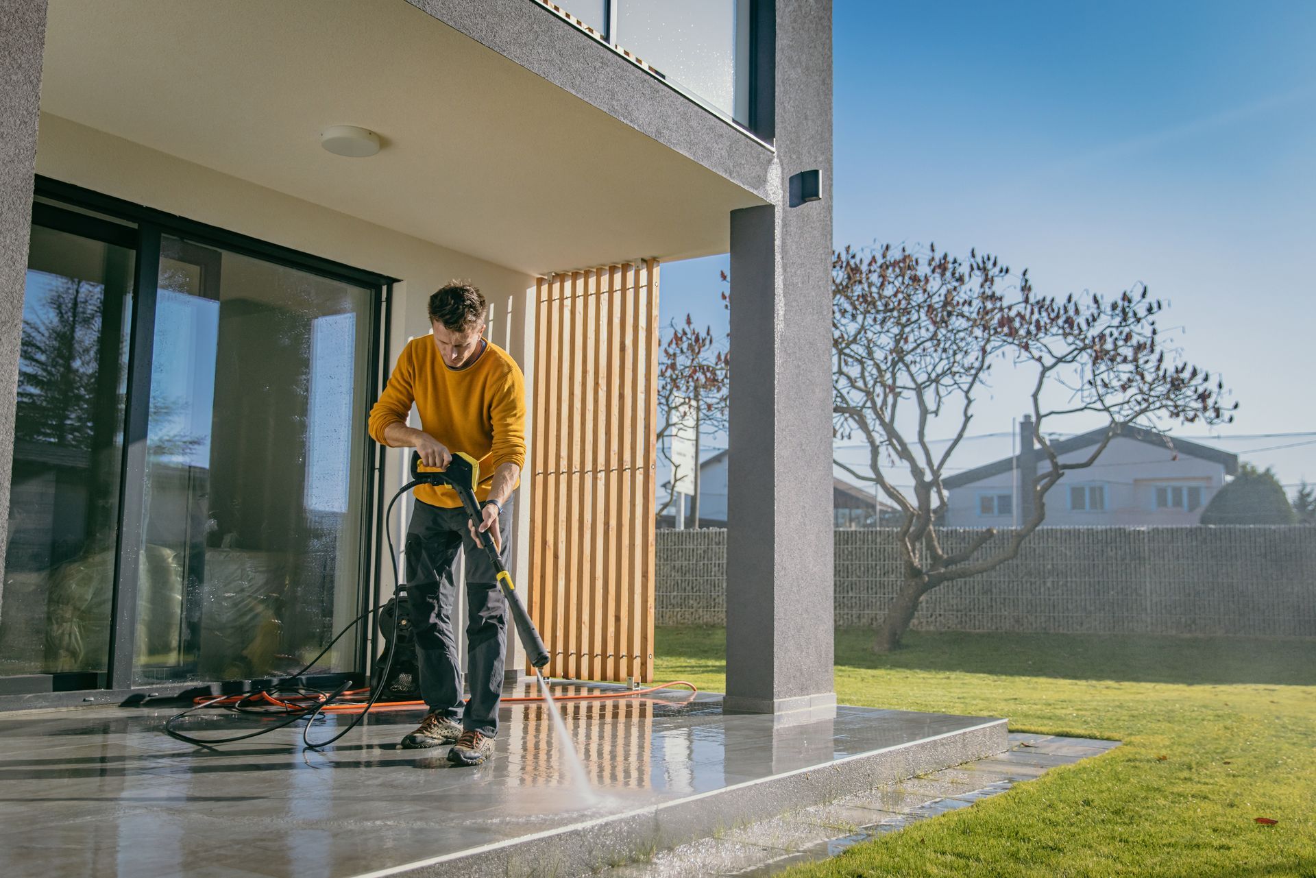 A man is cleaning a patio with a high-pressure washer — Cave Spring, GA — Straight Shooter Pressure Washing