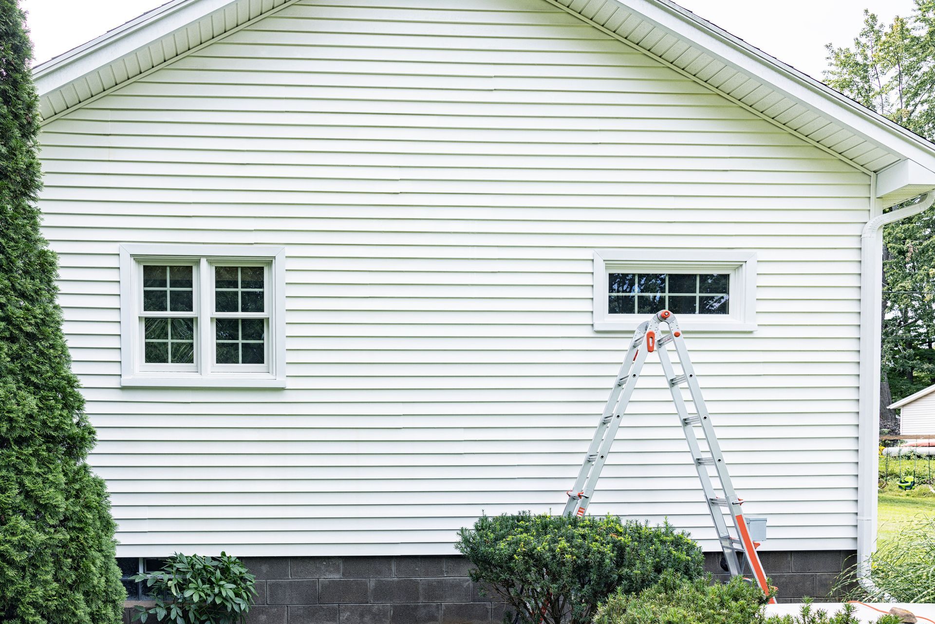 A man is cleaning the driveway of a house with a pressure washer — Cave Spring, GA — Straight Shooter Pressure Washing