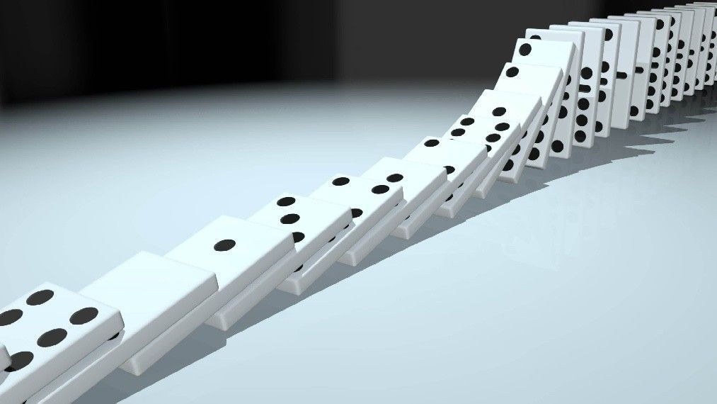 White dominoes lined up, falling in sequence.