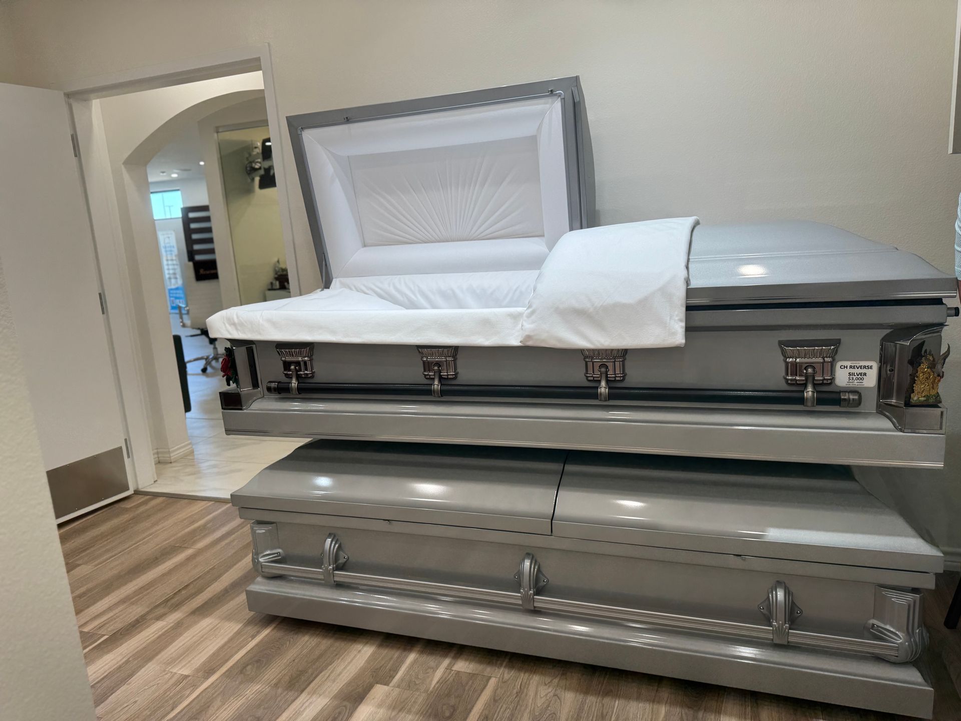 Open white casket with white lining in a funeral home room