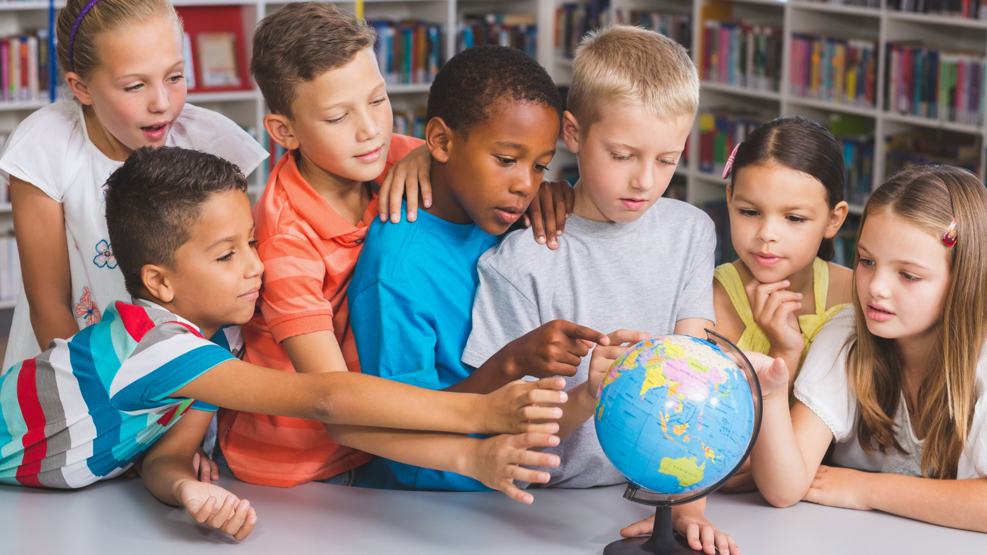 Children gathered around a globe in a classroom, pointing and looking closely together.