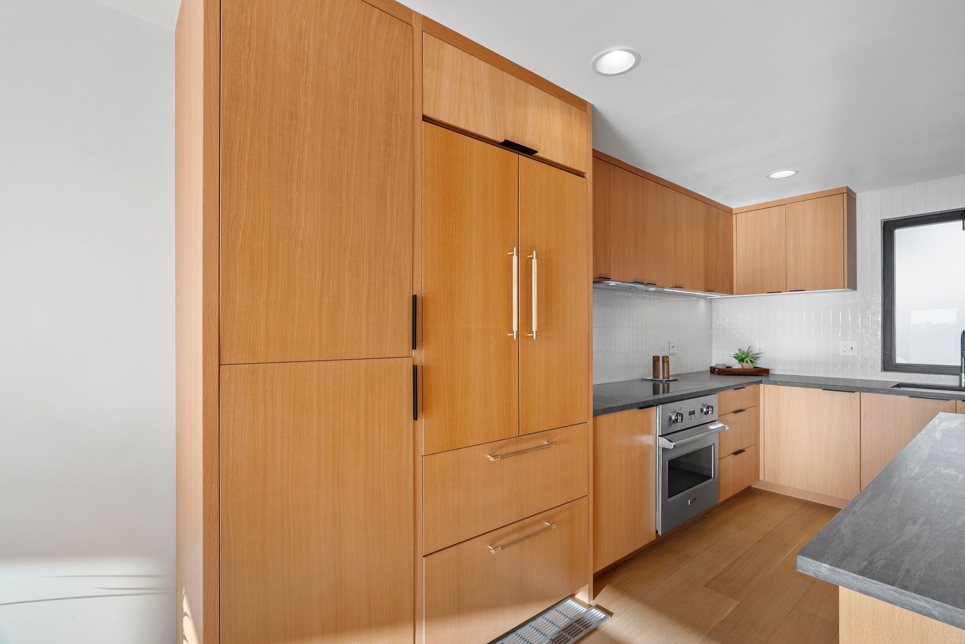 Modern kitchen with wood cabinets, stainless steel appliances, and a window over the counter