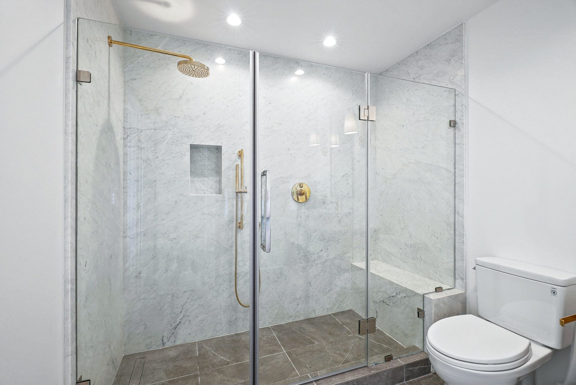 Modern bathroom with glass shower enclosure and white toilet