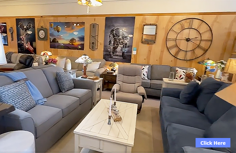 A furniture store interior with sofas, tables, lamps, and wall art.