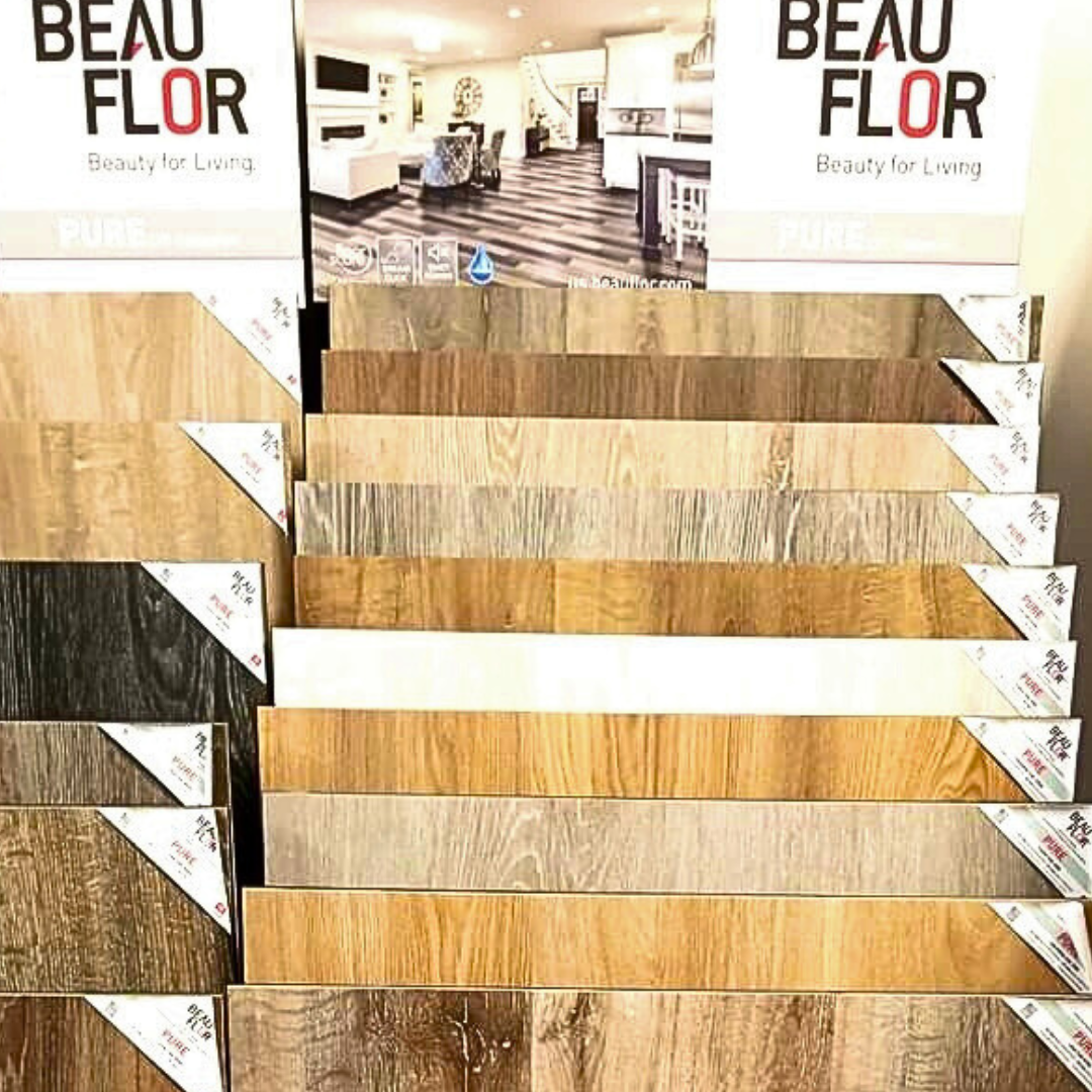Display of Beauflor flooring samples in various wood grain colors.