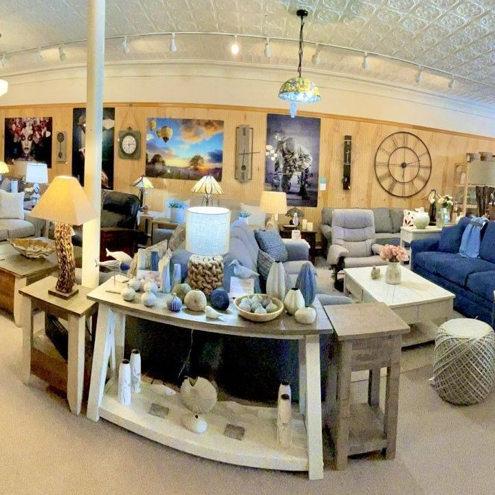 Furniture store interior with sofas, lamps, tables, and artwork.