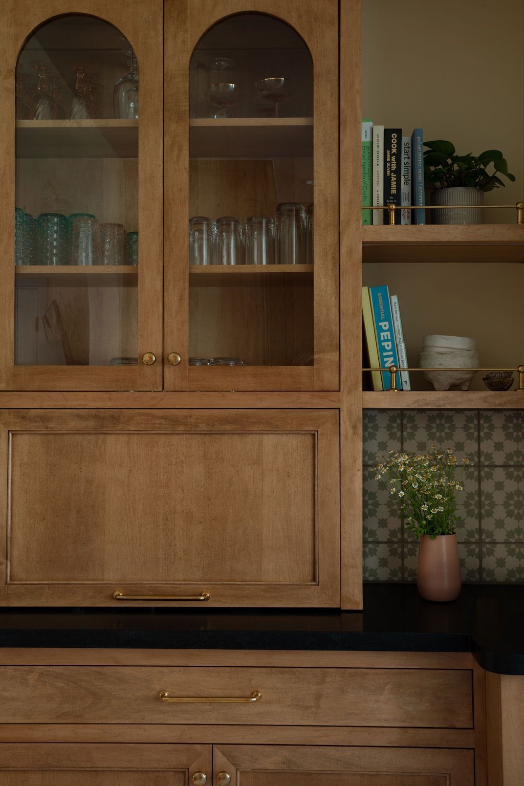 Wooden glass cupboard with various drinking glasses inside.