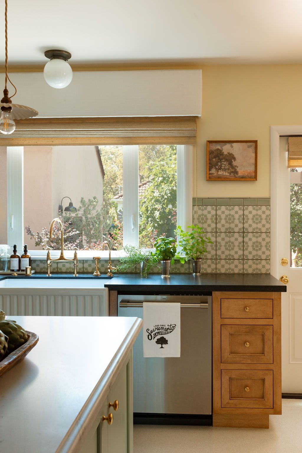 Kitchen remodel with patterned tile backsplash, wood cabinetry, and a window above the sink.