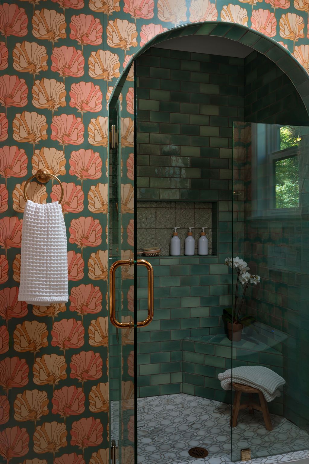Walk-in shower with dark green tile and a glass enclosure.