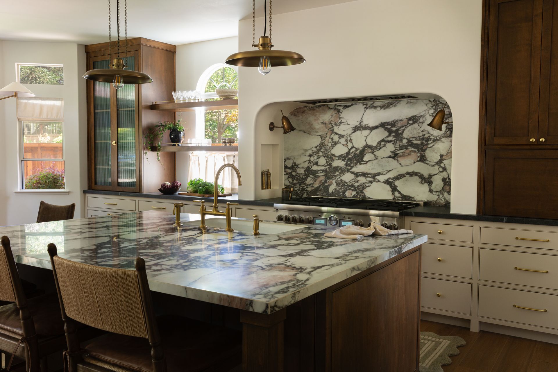 Luxury kitchen remodel featuring a statement marble island, dark wood cabinets, and elegant brass fixtures.