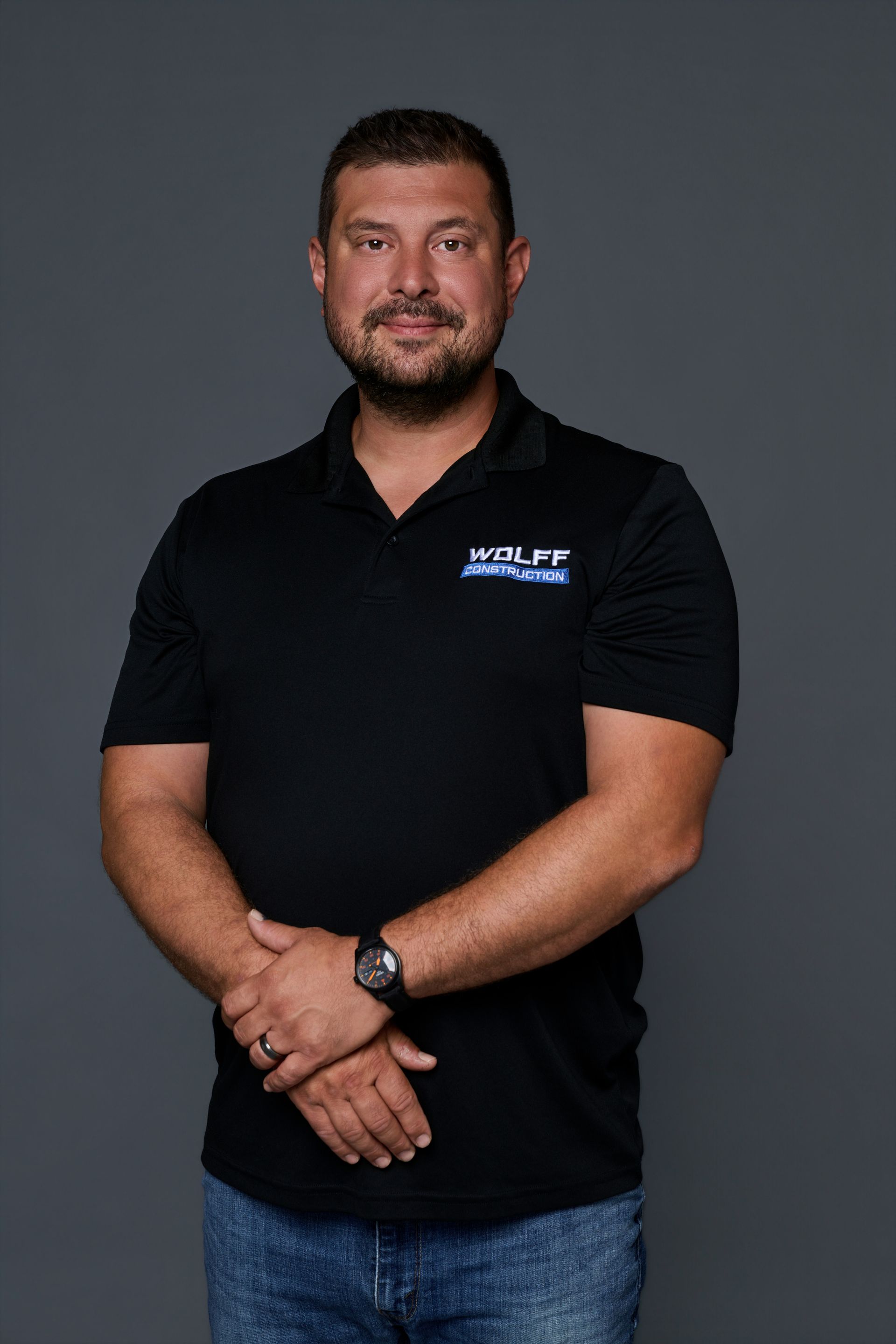 Headshot of Jared Schneider, Lead Project Manager at Wolff Construction, in a black polo and cap.