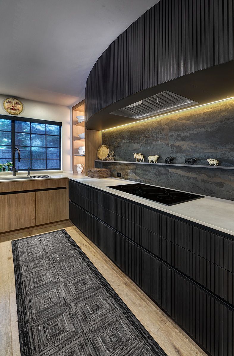 Kitchen with dark lower cabinetry, light wood upper cabinets, and under-cabinet lighting.