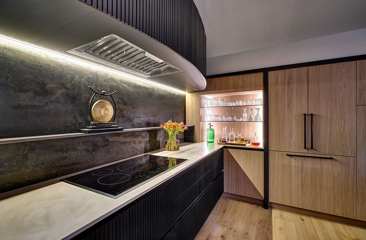 Kitchen cooktop area with dark cabinetry and under-cabinet LED lighting.