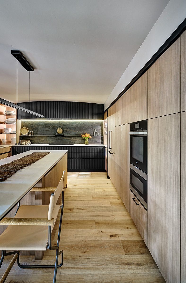 Kitchen with built-in appliances, wood cabinetry, and pull-out storage.
