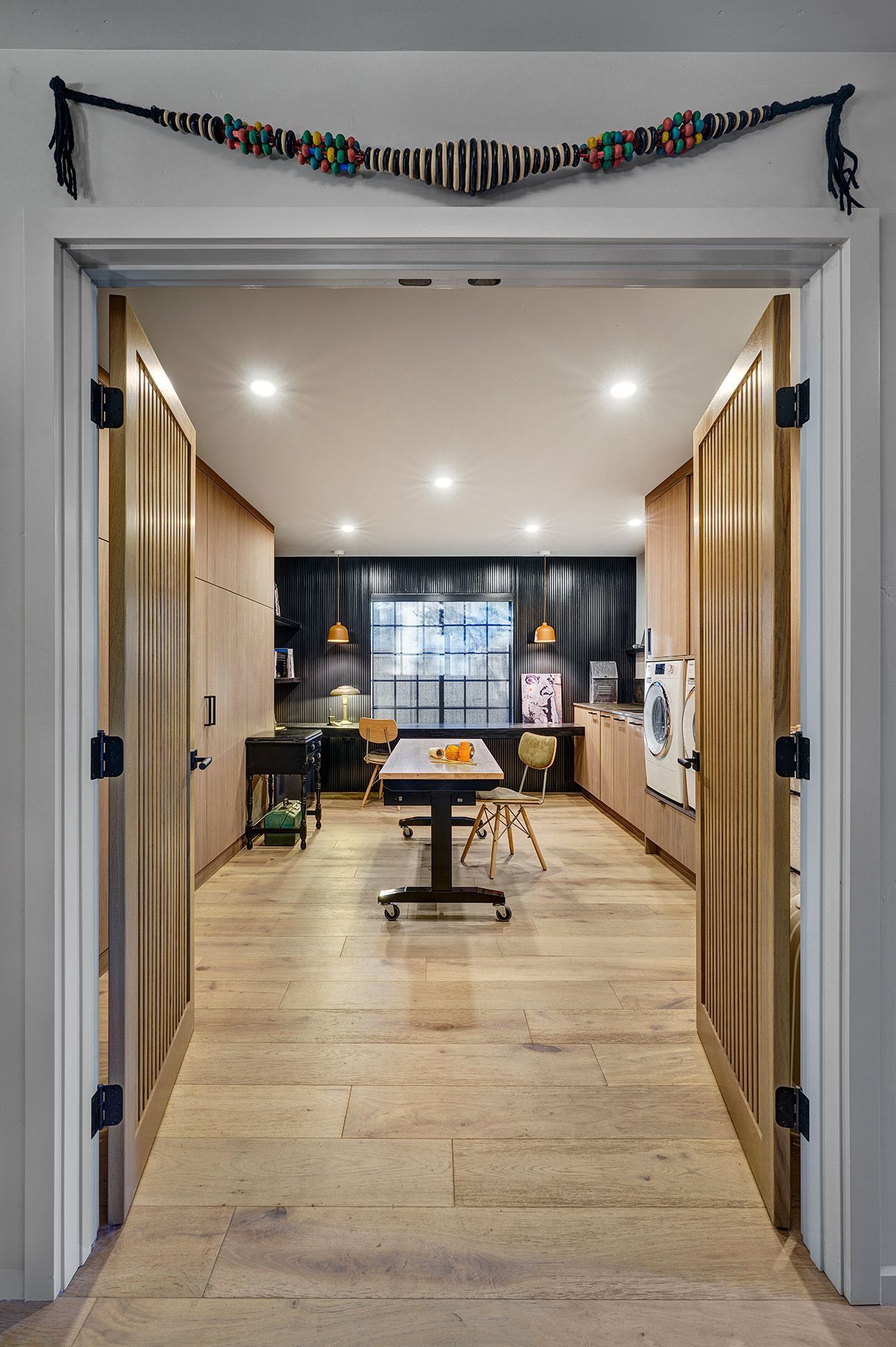 Hallway with wood slat partition, light floors, and a dark accent wall.