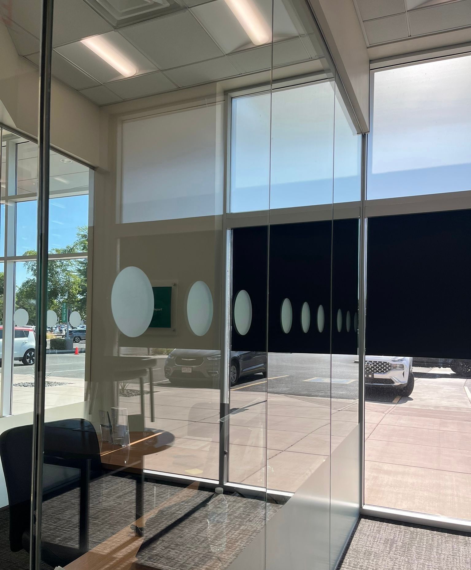 Modern glass storefront interior with circular decals and a bright street view outside