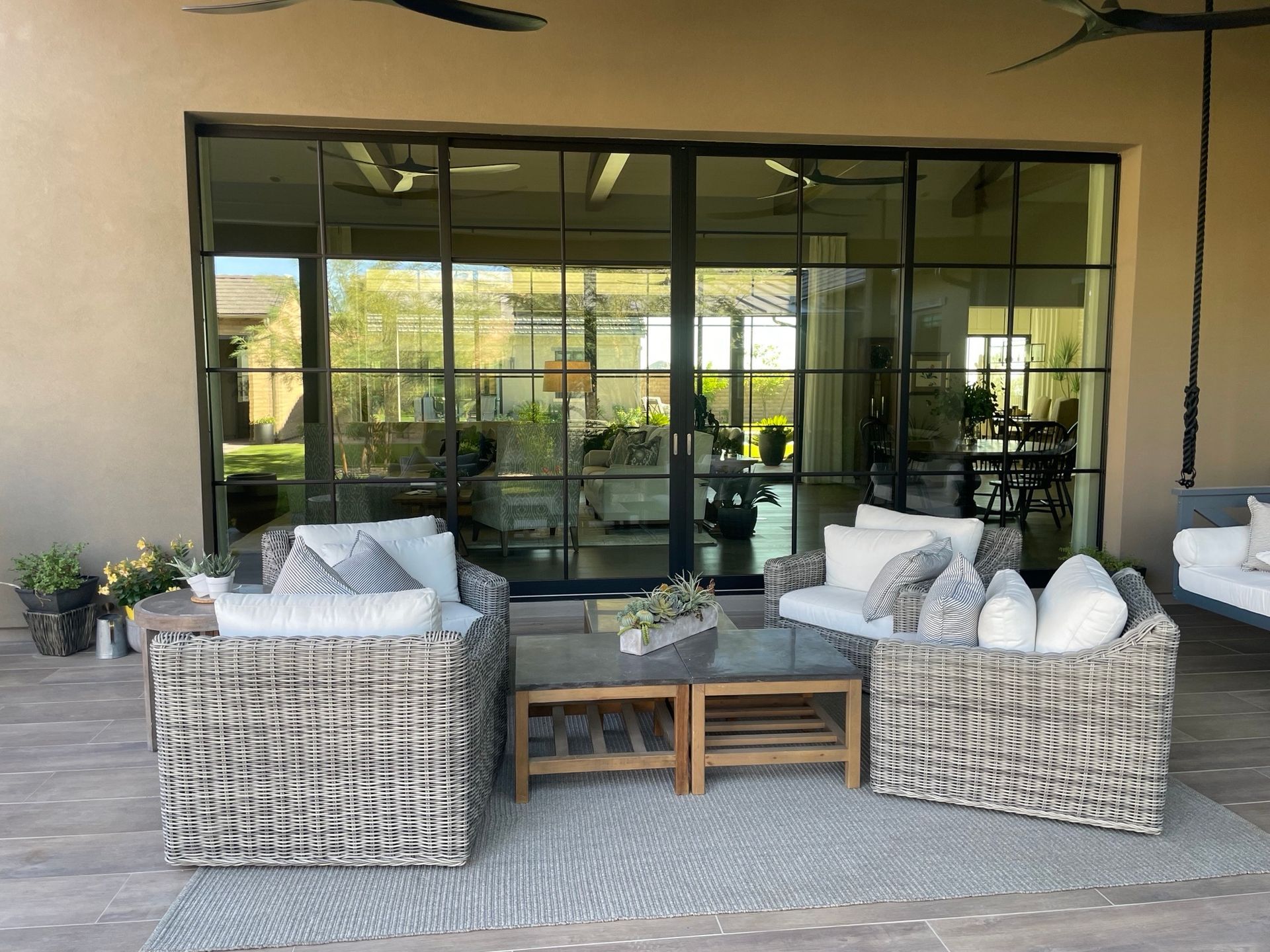 Covered patio with wicker sofa and chairs facing glass sliding doors