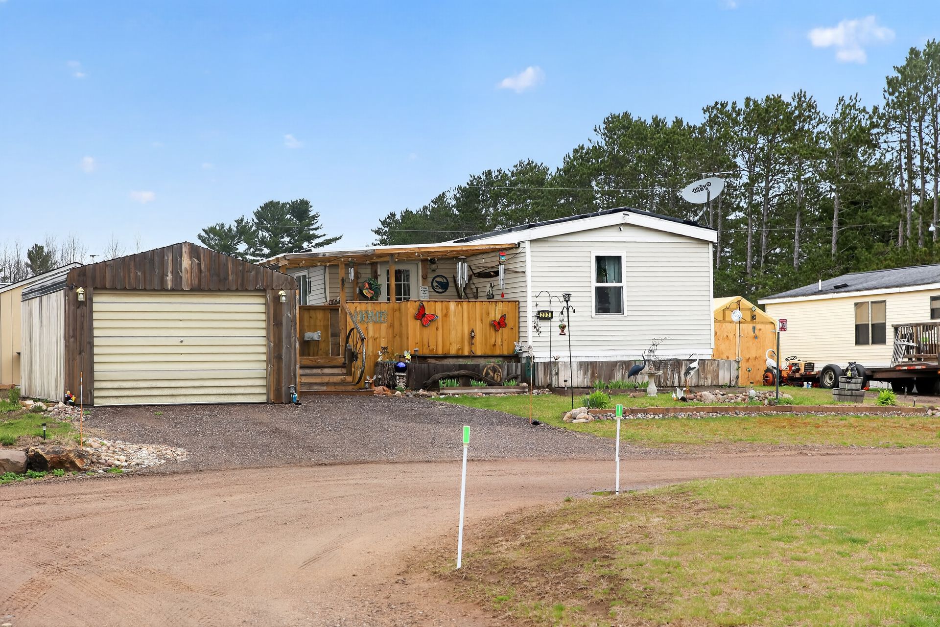 Row of mobile homes along a pathway, evening lighting, pale blue and white colors.