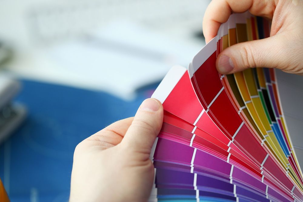 A Person Is Holding A Rainbow Of Colors In Their Hands — Mid Coast Coatings In Kempsey, NSW