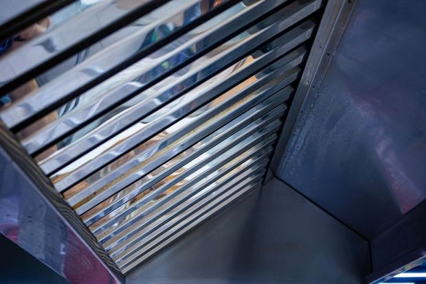 Metal stairwell seen from below with diagonal railings and blue-gray walls