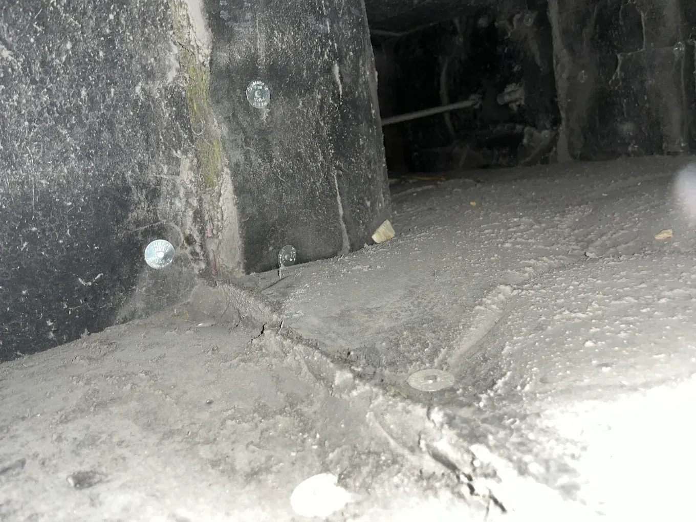 Dusty concrete tunnel floor with a dark opening in the background