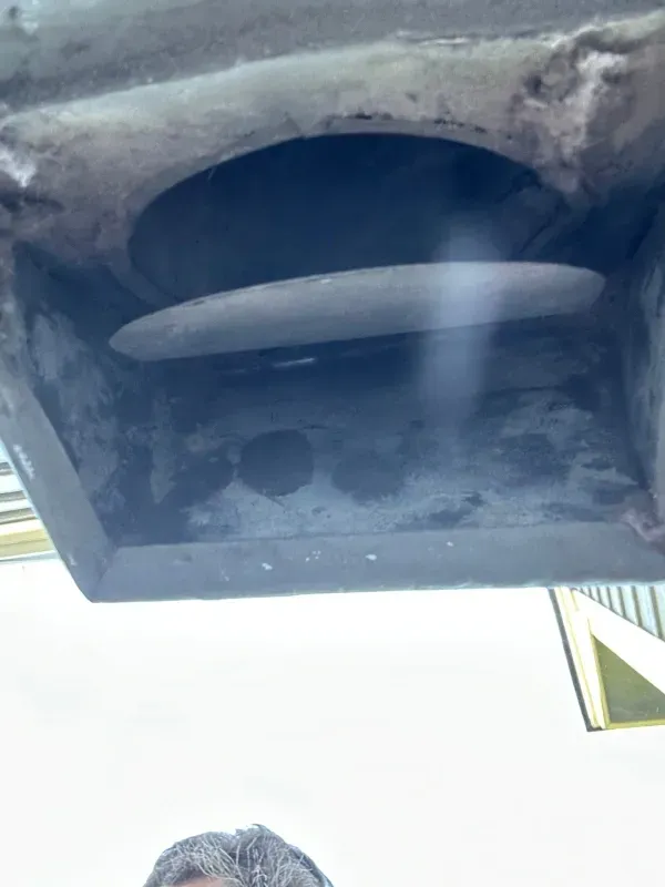 Close-up of a vehicle's undercarriage with a circular component and metal surfaces