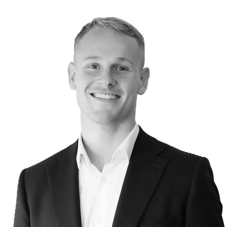 Smiling man in a suit and open white shirt.