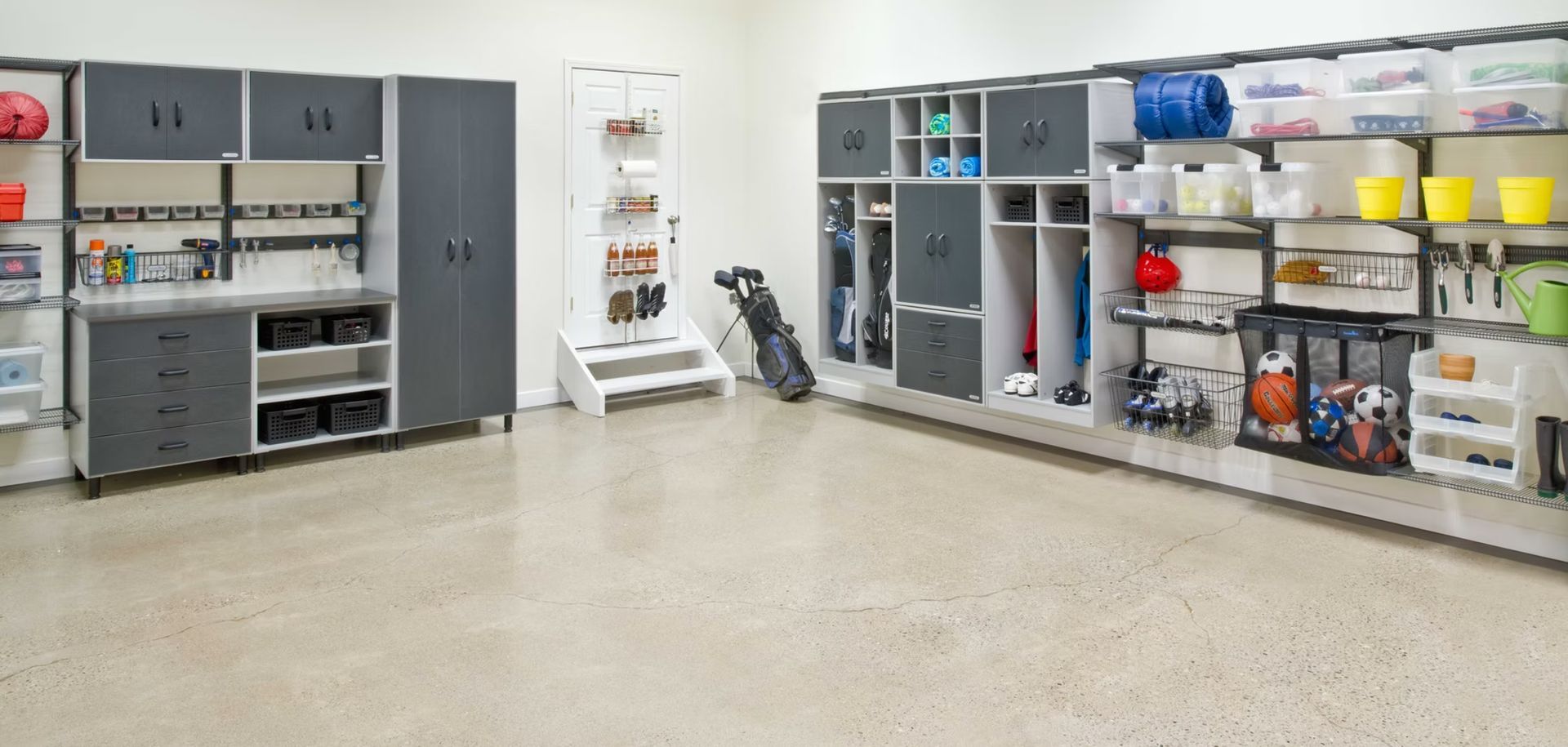 Neat industrial storage room with gray cabinets, shelves of supplies, and a vacuum on a polished concrete floor